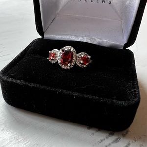 3 stone garnet ring with surrounding diamonds
